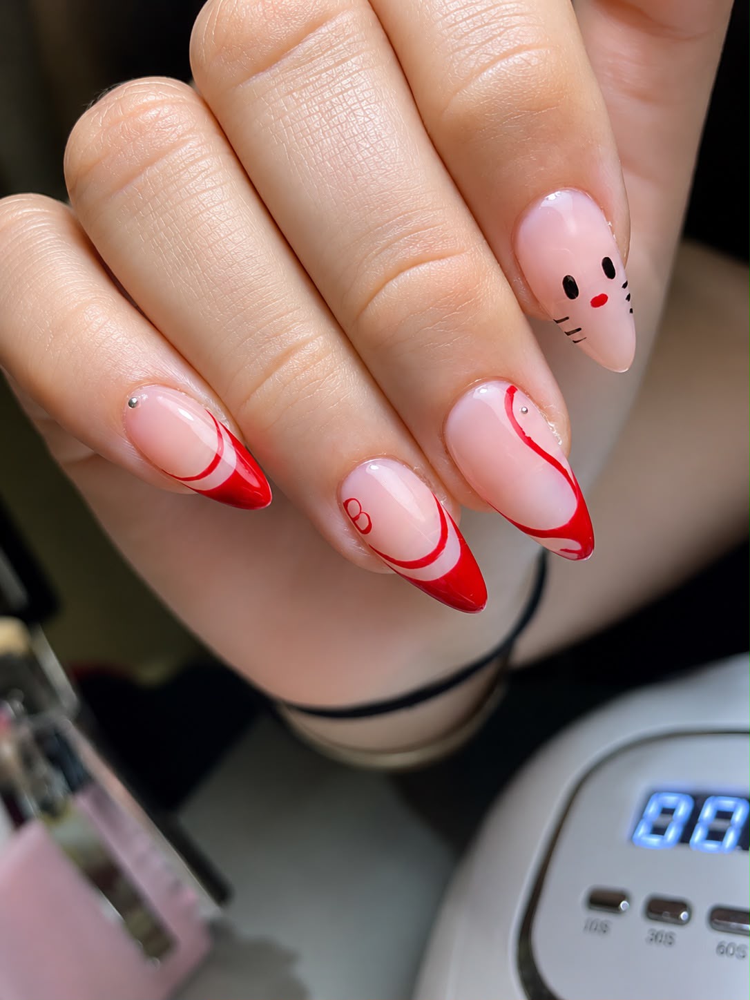 Nail art rojo con swirls y diseño a mano alzada